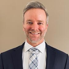 Brian smiling at the camera, wearing a suit